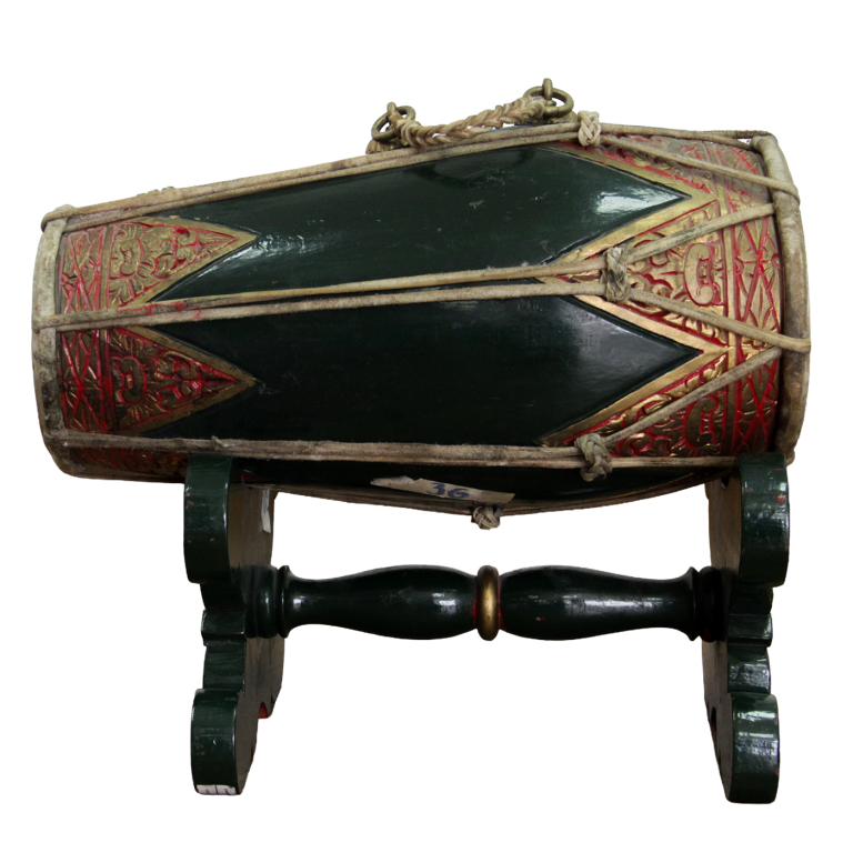 Tambor de doble parche, verde y rojo, con cuerdas de tensión, sobre soporte tallado.