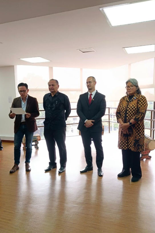 Cuatro personas de pie durante el acto de apertura; una de ellas lee las palabras de inauguración.