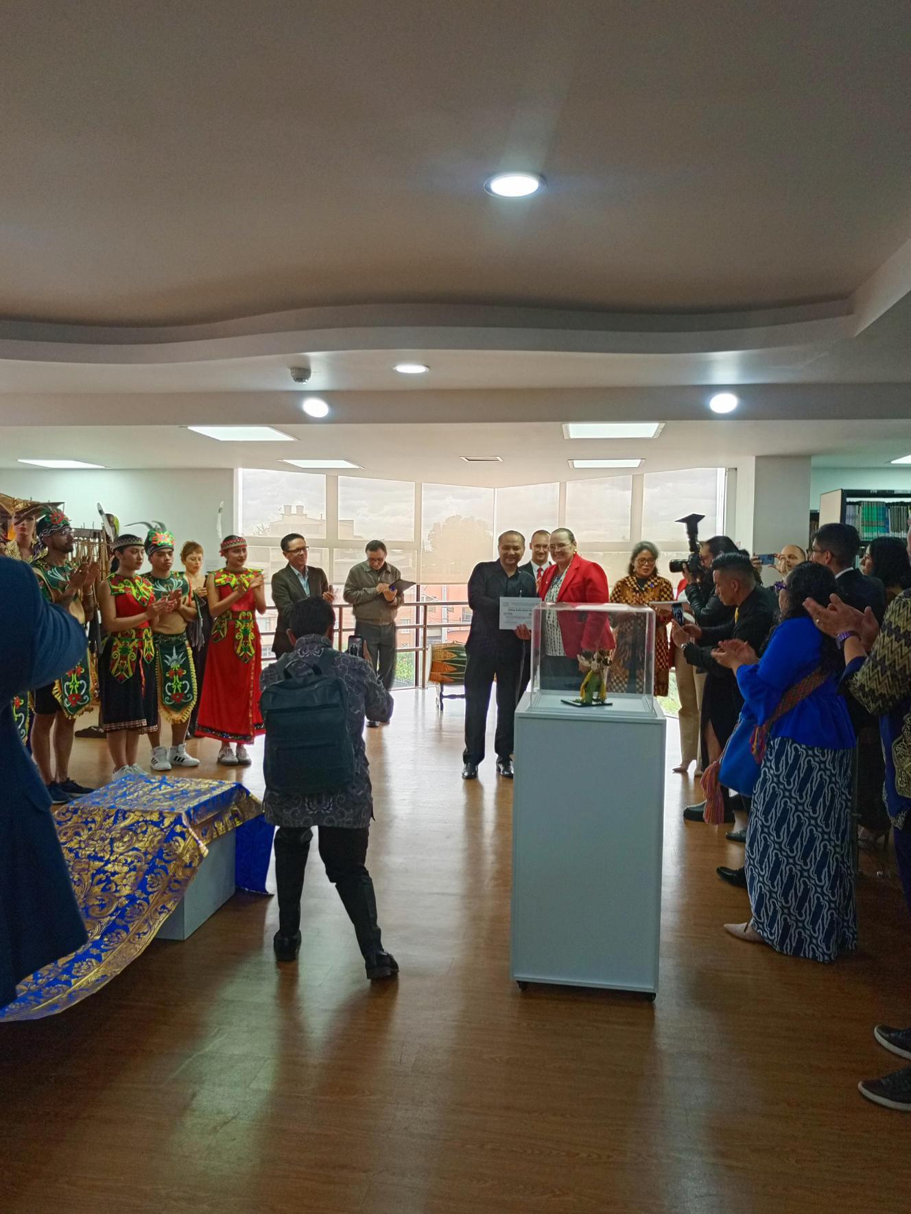 Público reunido en la sala durante el acto de apertura, alrededor de una vitrina central.